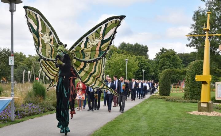 Stelzenläufer und Fahnenträger gingen den rund 250 Besuchern bei der Eröffnung der Blumenschau 2019 voran. Am Mittwochvormittag wurde die Hauptveranstaltung der Blumenschau im Stadtpark feierlich eröffnet. Bild: Ute Müller