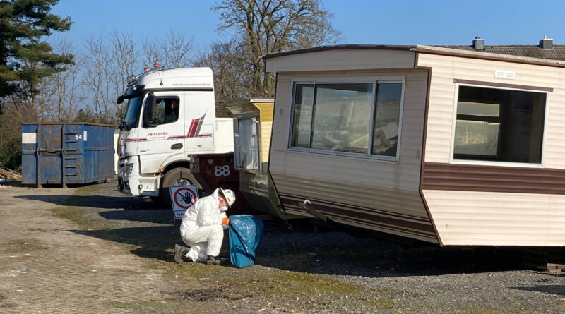 Ein Mitarbeiter einer Fachfirma sammelt in Schutzkleidung Rückstände von asbesthaltigen Faserzementplatten ein, die bei dem Brand eines illegalen Drogenlabors auf einem Grundstück in der Carl-Zeiss-Straße in Nordhorn zerstört worden sind. (Landkreis Grafschaft Bentheim)